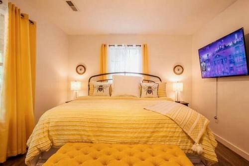 a bedroom with a large bed with a yellow blanket at BEES KNEES A-frame Cabin for 2 hot tub wifi in Gatlinburg