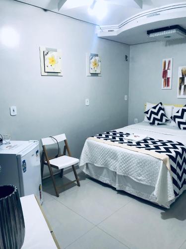 een slaapkamer met een bed en een stoel erin bij Hotel Pousada-LG in Breves