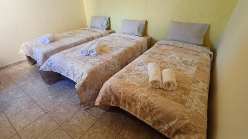 three beds are lined up in a room at Casa amarela - Perto do Centro in Poços de Caldas