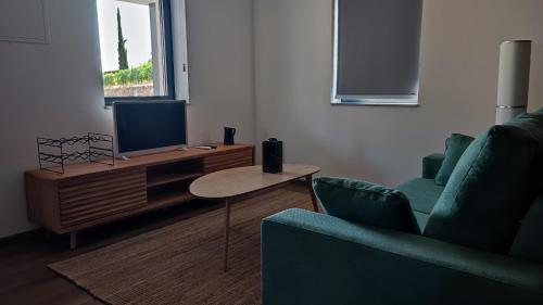 a living room with a tv and a couch and a table at Casa da Corredoura in Santa Marta de Penaguião