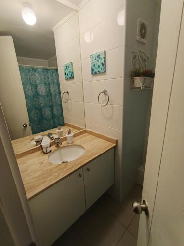 un bagno con lavandino e specchio di Apartamento amoblado por Dia a Calama