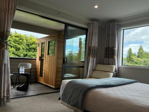 a bedroom with a bed and a large window at Tamahere Lifestyle in Tamahere