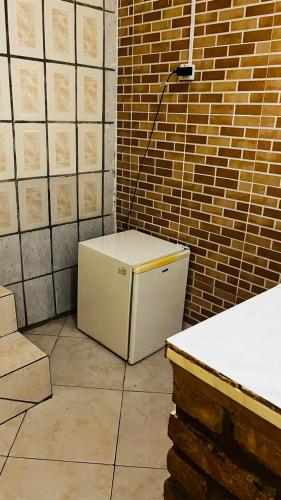 un piccolo frigorifero bianco in una stanza con un muro di mattoni di Casa63 a Lençóis