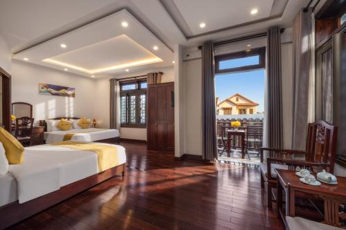 een slaapkamer met een bed en een groot raam bij Paradise Boutique Hoi An in Hội An