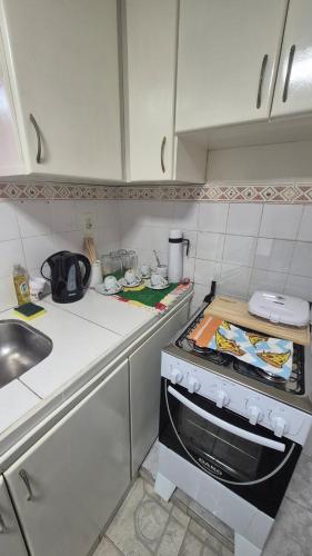 een keuken met een spoelbak en een fornuis bovenste oven bij Apartmento en Encarnación in Encarnación