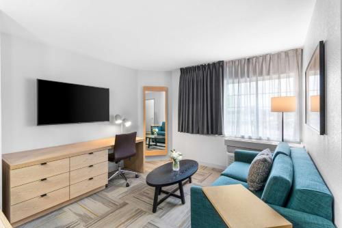 a living room with a blue couch and a desk at Sonesta Simply Suites Austin South in Austin