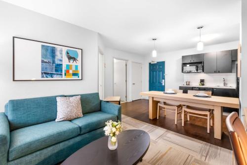 a living room with a blue couch and a table at Sonesta Simply Suites Austin South in Austin