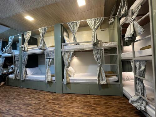 a room with three bunk beds in it at Goldsport Dormitory in Jāmb