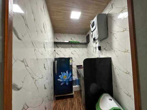 a room with a refrigerator and a tv on a wall at Goldsport Dormitory in Jāmb