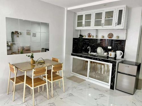 une cuisine avec une table, des chaises et un évier dans l'établissement 3Ks Transient House - Kyle Suite, à Romblon