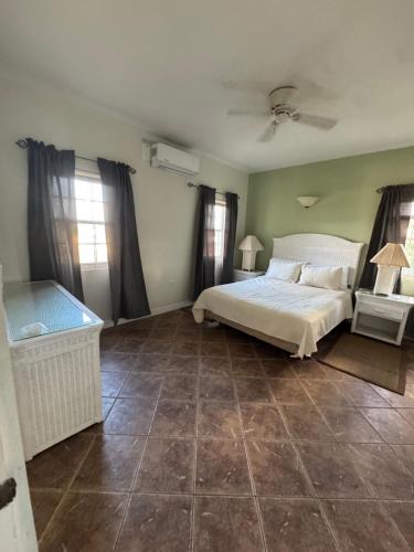 sypialnia z białym łóżkiem i kafelkową podłogą w obiekcie The Palms apt 2 w mieście Cedar Grove
