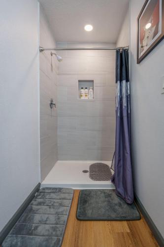 a bathroom with a shower with a purple shower curtain at Stylish & Quiet 3BD Sleeps 8 Near Stadium & Downtown in Jacksonville