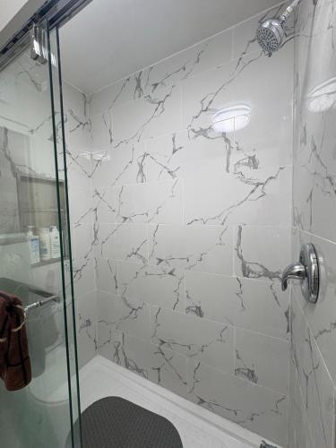 a bathroom with a shower with a glass door at Cozy 3BR House Near Airport & Transit! in Mississauga