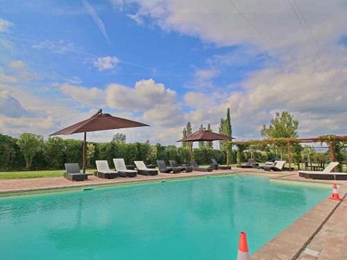 a swimming pool with lounge chairs and umbrellas at Modern holiday home in Foligno - Loc with pool in Case Vecchie