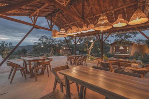 un restaurant avec des tables et des chaises en bois et des lumières dans l'établissement Hotel Ambil, à Barichara