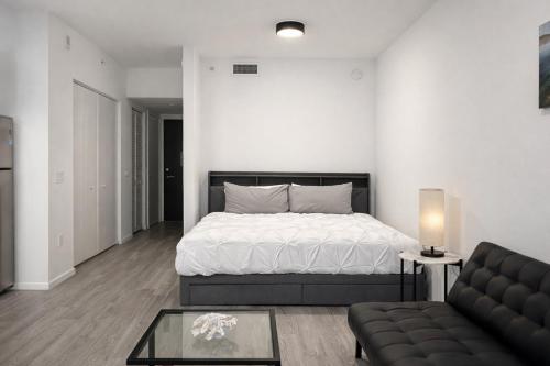 een witte slaapkamer met een bed en een bank bij Stylish Studio in Bayside Brickell Miami in Miami