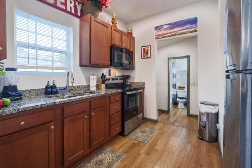 a kitchen with wooden cabinets and a sink and a refrigerator at Stylish & Quiet 3BD Sleeps 8 Near Stadium & Downtown in Jacksonville