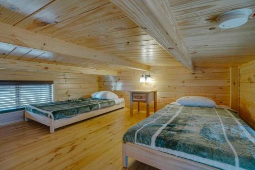 two beds in a room with wooden walls at Angel Fire RV Resort in Angel Fire