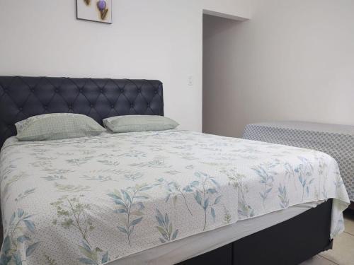 a bedroom with a bed with a blue and white comforter at Espaço da Paz e Serenidade in Praia Grande
