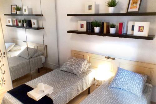 mały pokój z 2 łóżkami i lustrem w obiekcie Casa Tortilla Gracia w Barcelonie