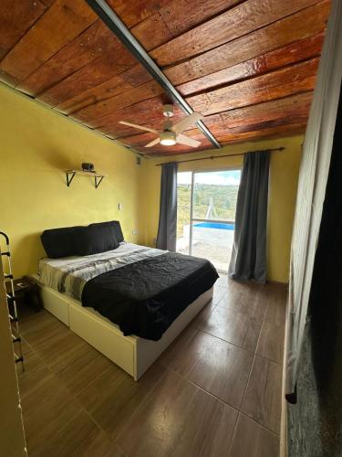 een slaapkamer met een bed en een houten plafond bij Ecolodge in Potrero de Garay
