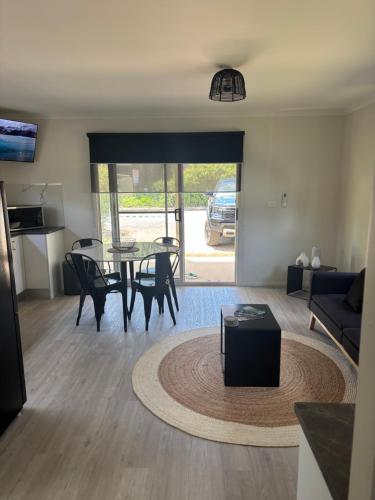 a living room with a table and chairs and a couch at Batemans Bay North Tourist Park in Benandarah