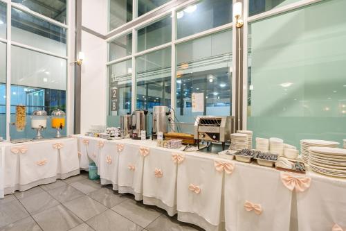 een buffetlijn met witte tafels en borden bij Prom Hotel in Bangkok