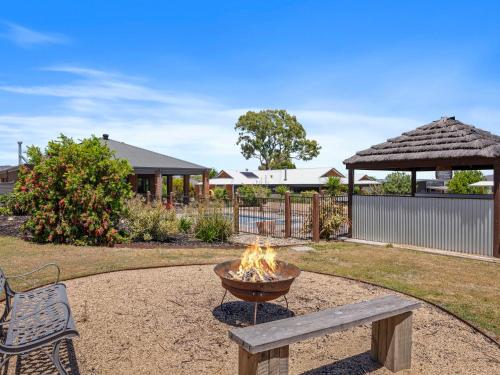 een vuurplaats en een bank in een tuin bij Dan's Rise in Mansfield