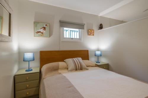 a bedroom with a bed and two lamps on night stands at Hibiscus Cottage in Ballina