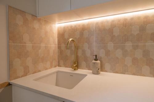 a bathroom with a sink with a faucet at Hibiscus Cottage in Ballina