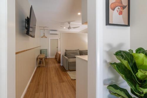 a hallway with a living room and a couch at Hibiscus Cottage in Ballina
