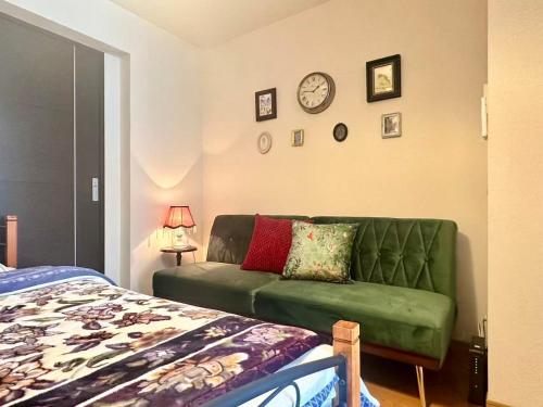 un salon avec un canapé vert et un lit dans l'établissement Mori de house in kobe 1, à Kobe
