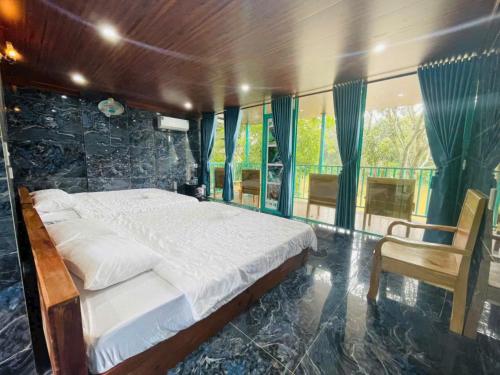 une chambre avec un grand lit avec un mur en pierre dans l'établissement Quang Minh River View Hotel, à Cat Tien