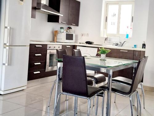a kitchen with a table with chairs and a refrigerator at Welcome to Malta in Il-Gżira