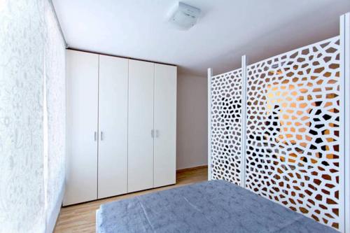 una camera da letto con armadi bianchi e un tappeto blu di Monovano in pieno centro a Palermo