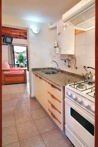 a kitchen with a stove and a sink at Posada Cerro Hotel in Santa Rosa de Calamuchita