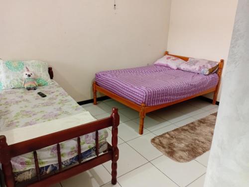 een slaapkamer met twee bedden en een bed en een kleed bij Kitnet das férias in Pontal do Paraná