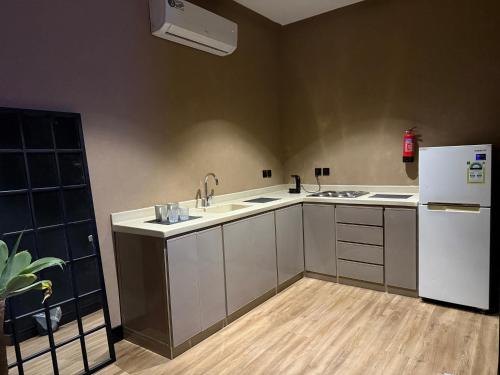 a kitchen with white cabinets and a white refrigerator at Cali chalets in Riyadh