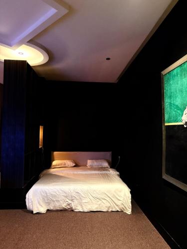 a bedroom with a bed in a black room at Cali chalets in Riyadh