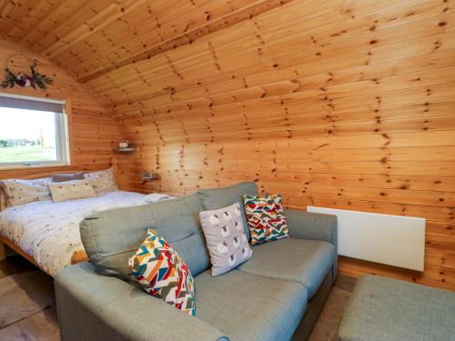 un soggiorno con un divano e un letto di Cherry a Ulverston