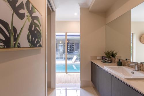 a bathroom with a sink and a mirror at Escapades @ Palm Cove in Palm Cove