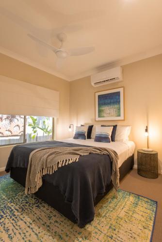a bedroom with a large bed and a window at Escapades @ Palm Cove in Palm Cove