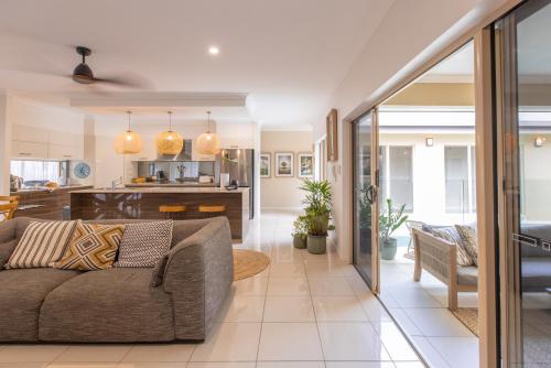 ein Wohnzimmer mit Sofa und eine Küche in der Unterkunft Escapades @ Palm Cove in Palm Cove