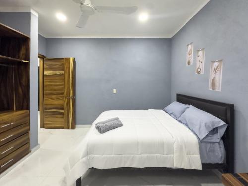 een slaapkamer met een groot wit bed met blauwe muren bij Estancia Sofia in Puerto Escondido