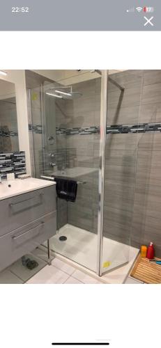 a bathroom with a glass shower and a sink at Le côte d opale bohème plage in Calais