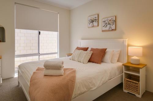 a bedroom with a large white bed and a window at Isla Escape Pet Friendly Dunsborough in Dunsborough
