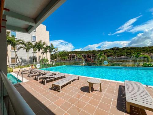 een zwembad met banken naast een resort bij Exceptional apartment to rest in Cartagena