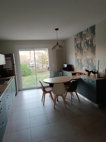 una cucina con tavolo e sedie e una sala da pranzo di Maison proche circuit 24h ad Arnage