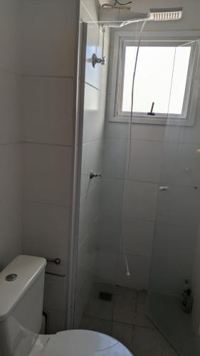 a white bathroom with a shower and a toilet at APTO EASY Poços de Caldas in Poços de Caldas