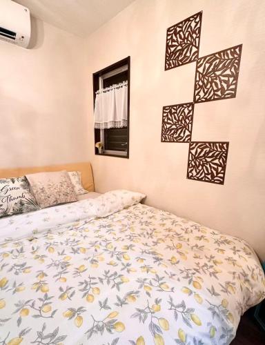 a bedroom with a bed and a cross on the wall at Mori de house in kobe 2 in Kobe